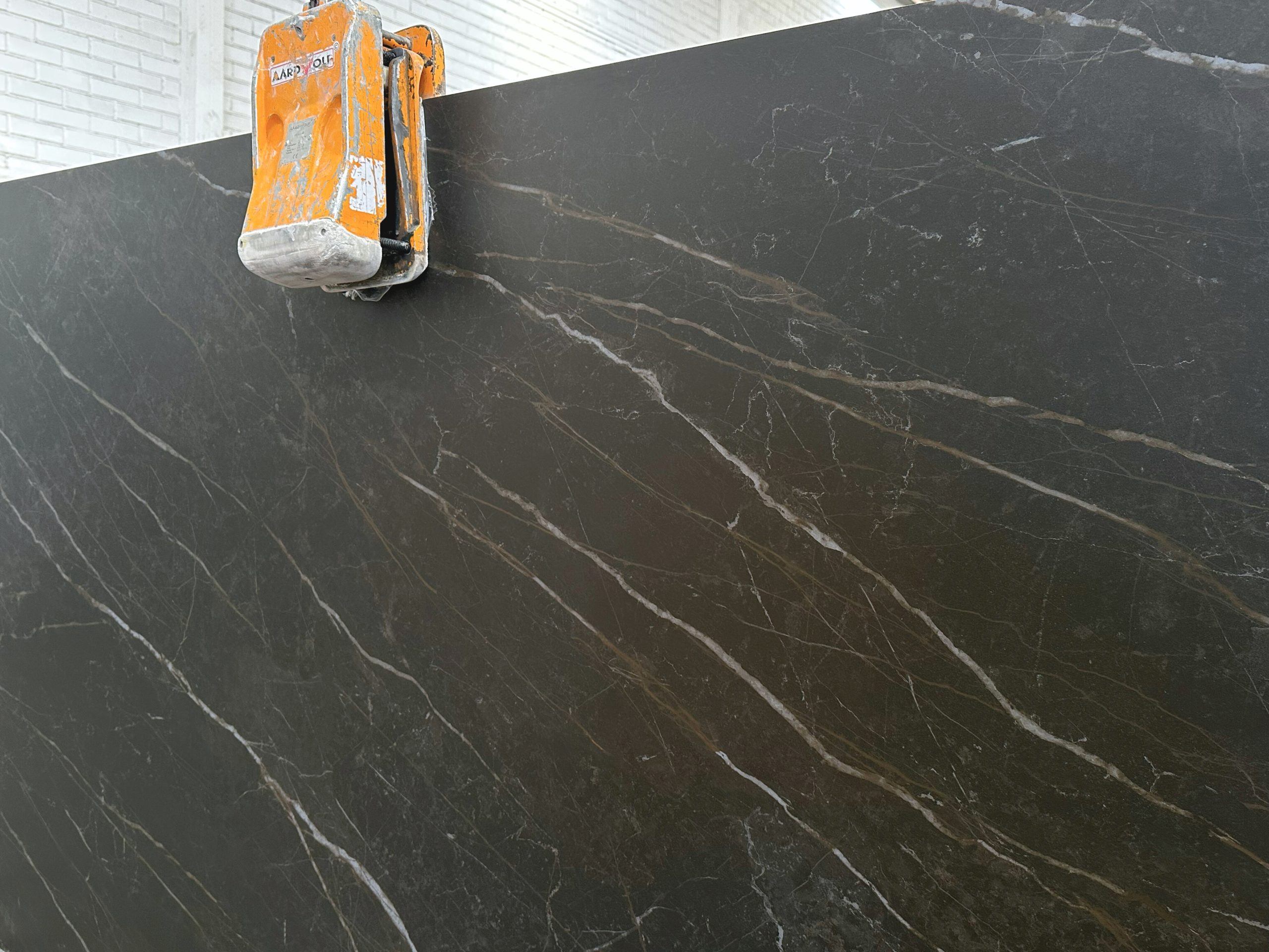 Detalle de vetas doradas sobre superficie oscura del Creastone Ultracompacto Laurent Golden