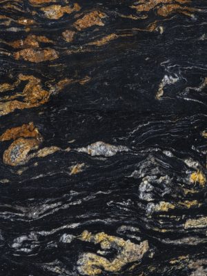 Textura de granito exótico Black Ember con fondo negro intenso y vetas doradas irregulares, utilizada en cubiertas y revestimientos premium