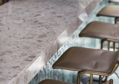 Primer plano de la cubierta de aglomerado de mármol Palladio Fenice en la barra del restaurante Casa Sanz, destacando su textura, grano fino y acabado pulido.