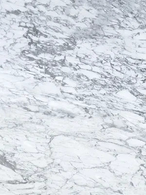 Mármol Carrara de fondo blanco con vetas grises irregulares, ideal para cubiertas y revestimientos interiores.