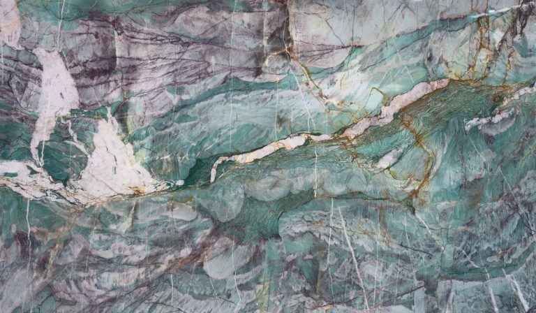 Detalle de veta de piedra natural Vezuvio con tonos verde esmeralda, lila y vetas doradas